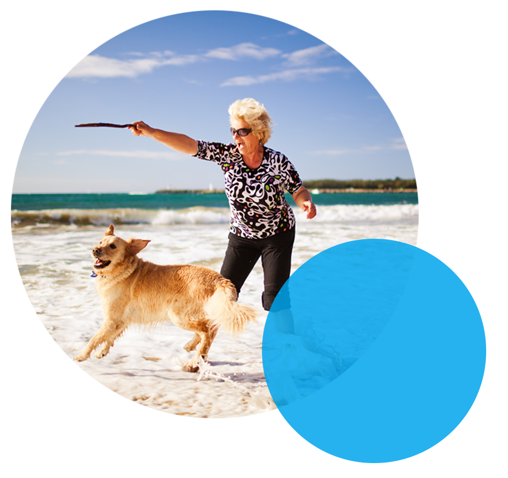 senior playing fetch with her dog on the beach