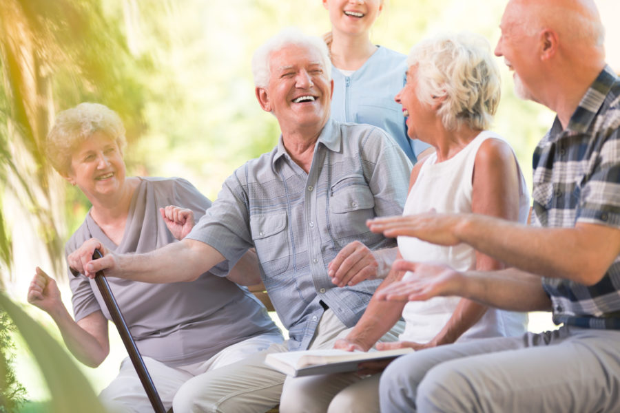 Group of smiling senior near senior apartment community