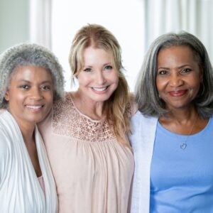 group of three older women smiling at camera
