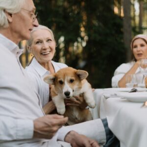 elderly friends sitting at table with a dog