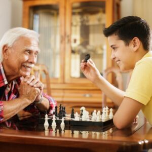 elderly man and grandson playing chess