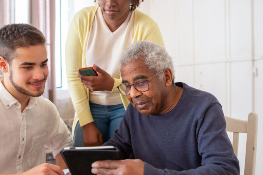 son helping elderly father use ipad