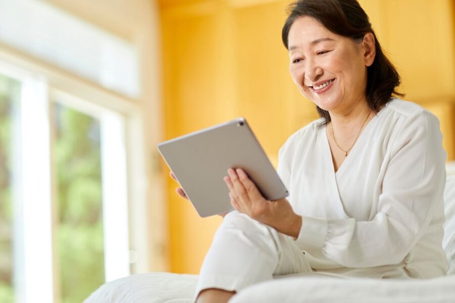 woman smiling at a tablet