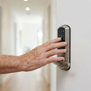 A close-up of a hand using a keyless smart lock on a door.